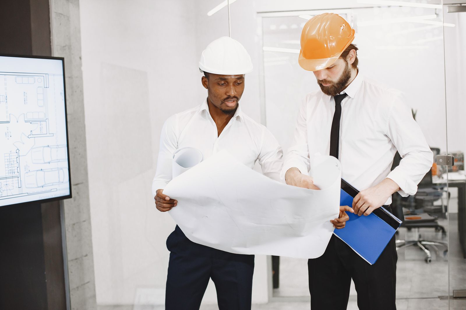 Two engineers reviewing a technical drawing to assess a proposed change
