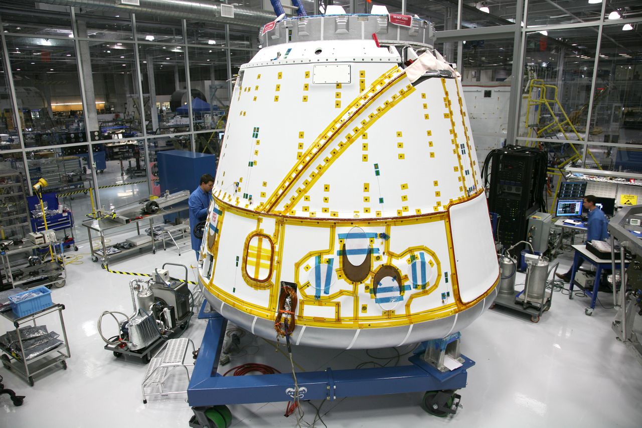 An aerospace capsule under assembly in a clean defense-manufacturing facility