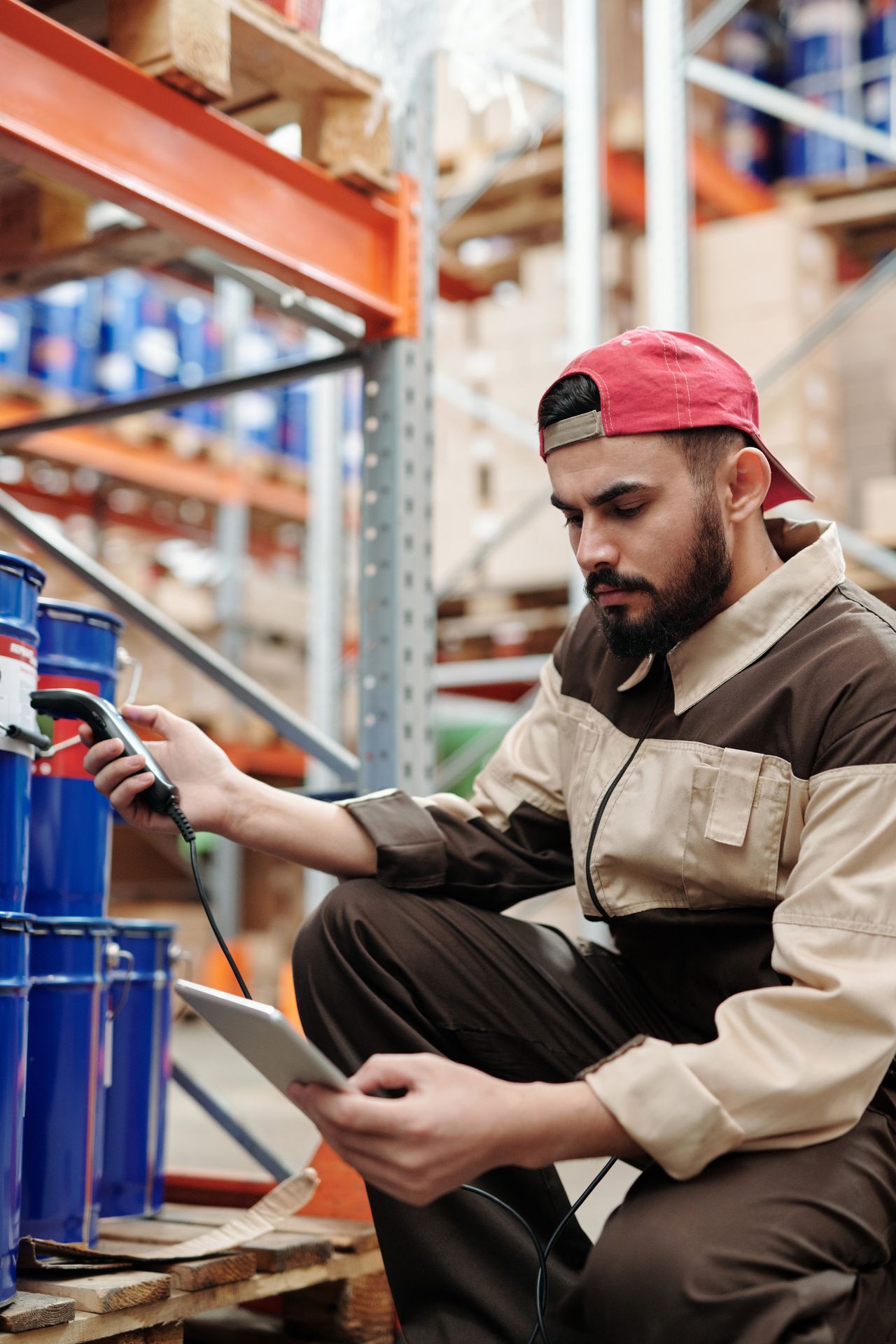 A worker scanning inventory by barcode at material shelving