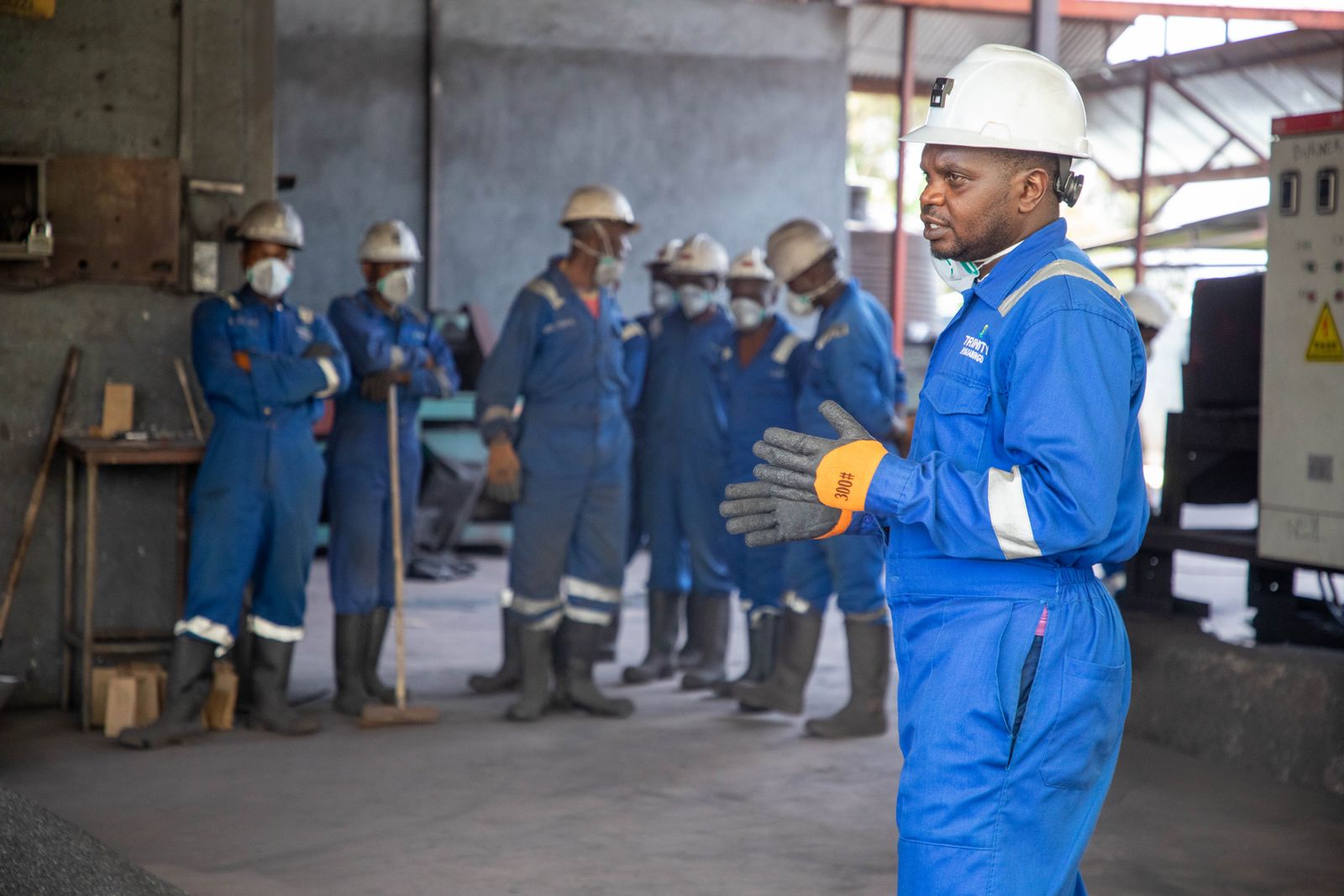A trainer leading a floor crew in protective equipment through a training session